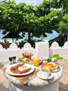 a breakfast table with food and drinks on a table at Zanzibar Retreat Hotel in Matemwe