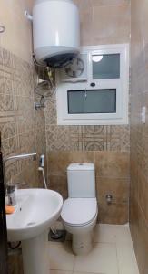 La petite salle de bains est pourvue de toilettes et d'un lavabo. dans l'établissement شقه على كورنيش المعادي, au Caire