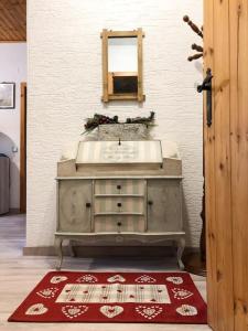 ein Badezimmer mit einem Waschbecken, einem Spiegel und einem roten Teppich in der Unterkunft Spazioso Angolo di Paradiso - Residence Erika (TN) in San Valentino