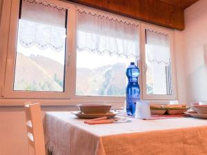 uma mesa com uma garrafa azul ao lado de uma janela em Spazioso Angolo di Paradiso - Residence Erika (TN) em San Valentino
