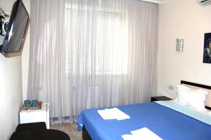 ein Schlafzimmer mit einem blauen Bett und einem Fenster in der Unterkunft Breeze Hotel in Odessa