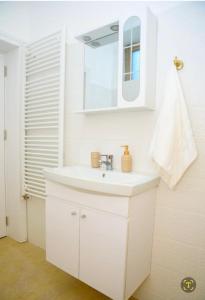 Baño blanco con lavabo y espejo en Bistro Centru Vechi Craiova, en Craiova