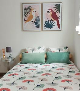 um quarto com uma cama com três fotografias na parede em Cozy Studio in Central Lisbon em Lisboa
