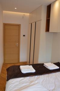 a bedroom with a bed with two towels on it at Unca in Belgrade