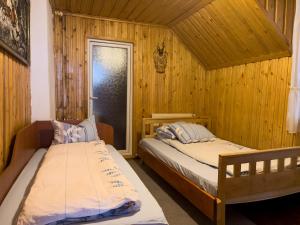 2 camas en una habitación con paredes de madera en CABANA CLAUDIA en Petroşani