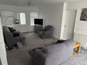 a living room with two couches and a tv at Devon Lodge in Worlingham