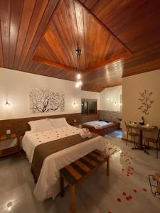 a bedroom with a large bed with a wooden ceiling at Verde da Mantiqueira Chalés in Visconde De Maua