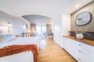a hotel room with a bed and a dining room at OCEANO Health Spa Hotel in Punta del Hidalgo +16 photos