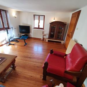 uma sala de estar com um sofá vermelho e uma mesa em Petite maison alsacienne dans un village au calme em Niederroedern