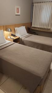 Een bed of bedden in een kamer bij Castelo Inn Hotel