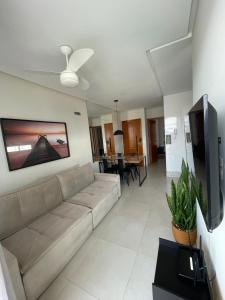 a living room with a couch and a flat screen tv at Apartamento Praia do Morro in Guarapari