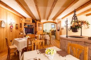 uma sala de jantar com mesas e cadeiras e uma lareira em Appartamento Le Colonne - Relais Villa Quercia em Tassullo