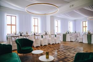 a banquet hall with tables and chairs in a room at Kounický dvůr in Dolní Kounice