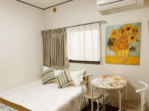 a room with a bed and a table and a painting at TOKYO/Shinjuku & Shibuya 10mins/5mins walk to subway stiaon/Kichijoji 15mins/Shimokitazawa 5mins/Louis House in Tokyo