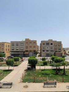 a park with benches and buildings in a city at Logement entier appartement Chez Mehdi in Fez