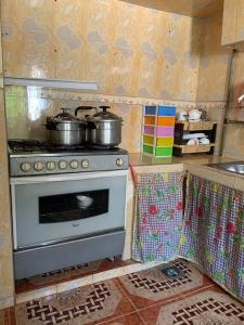 a kitchen with a stove with pots and pans on it at Logement entier appartement Chez Mehdi in Fez