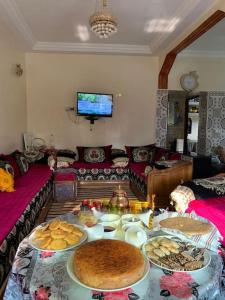 a living room with a table with plates of food at Logement entier appartement Chez Mehdi in Fez
