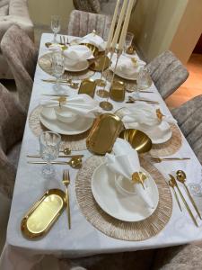 アガディールにあるMagnifique appartement a la marina d agadirの金白皿、銀器が並ぶテーブル