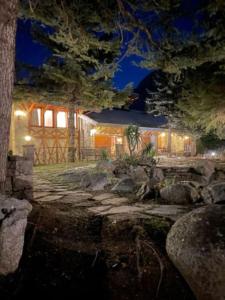 una casa di notte con una recinzione e alberi di Hotel Vallibierna a Benasque