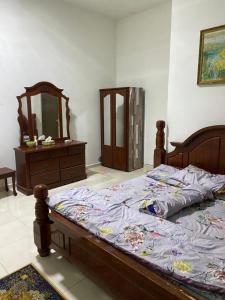 ein Schlafzimmer mit einem Bett mit einer Kommode und einem Spiegel in der Unterkunft Homestay Sweetcorn in Kampong Alor Gajah