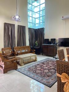 ein Wohnzimmer mit einem Sofa und einem Tisch in der Unterkunft Homestay Sweetcorn in Kampong Alor Gajah
