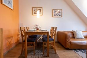 a dining room table with chairs and a couch at ST4-09 - Ferienwohnung in Dorum-Neufeld