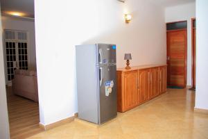 a refrigerator sitting in a living room next to a table at Kindo Kicha Farmhouse in Moshi