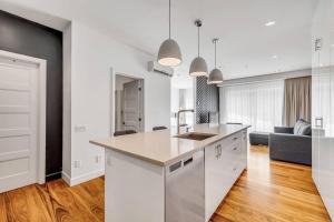 a kitchen with white cabinets and a living room at Initial / Ilot / Downtown Québec in Quebec City