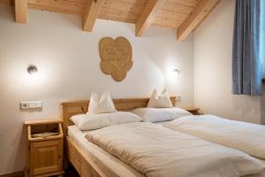 two beds in a room with a heart on the wall at Kranebitterhof Apt Alpenrose in Valdaora