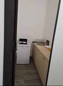 a kitchen with a white refrigerator and a microwave at Bistro Centru Vechi Craiova in Craiova