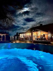 een zwembad voor een huis 's nachts bij Sasaki Sauna i Bania in Szczutków