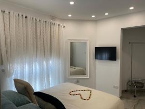 een slaapkamer met een bed, een spiegel en een bank bij Maranello Court, Apartment 1 in Marsaxlokk