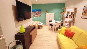 un soggiorno con divano giallo e TV a schermo piatto di Il Loft di Pieve a Città della Pieve