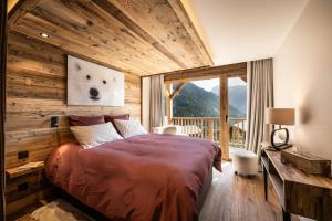 een slaapkamer met een bed met een houten muur bij Résidence Ancolie in Champagny-en-Vanoise