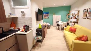 cocina y sala de estar con sofá amarillo en Il Loft di Pieve, en Città della Pieve
