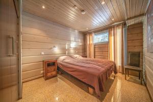 レヴィにあるLevillas Utsuvaara Villasの木製の壁のベッドルーム1室(ベッド1台付)