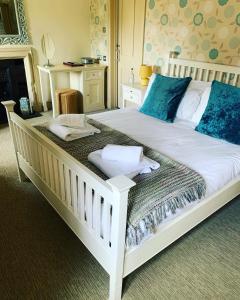 a bedroom with a large white bed with blue pillows at The Red Lion in Lacock +4 photos