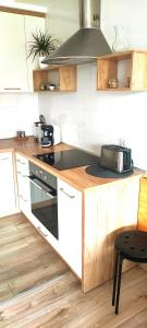 a kitchen with white cabinets and a stove top oven at Apartament nad Jeziorem w Olecku in Olecko