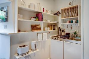 a kitchen with white cabinets and a counter top at The Dovecote in Woodstock