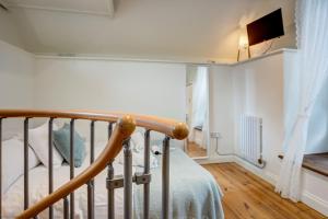 a bedroom with a bed and a tv on a wall at The Dovecote in Woodstock