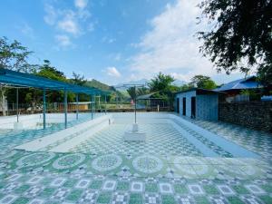 a swimming pool with a tile floor and a building at Mường Lò Corner in Yên Bái