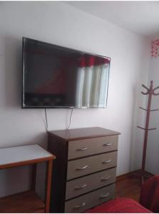 een slaapkamer met een dressoir en een flatscreen-tv aan de muur bij Hotel D'Gloria in Churín