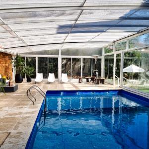 una piscina en una casa con una extensión de cristal en Posada Mia Nonna en Villa General Belgrano