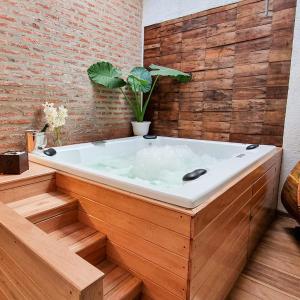 uma banheira num quarto com uma parede de tijolos em Posada Mia Nonna em Villa General Belgrano