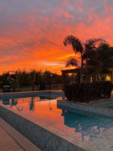a sunset over a swimming pool at a resort at Rancho Terra in Dourados