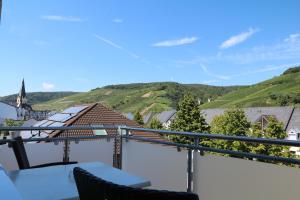 einen Balkon mit einem Tisch, Stühlen und Bergen in der Unterkunft Hotel Ännchen in Bad Neuenahr-Ahrweiler