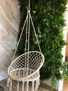 a rattan hanging chair in front of a plant at Silveroks Hotel in Bukovel