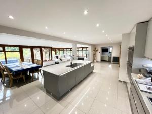 a kitchen and living room with a sink and a table at Reads Lodge in Waterlooville