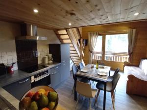 een keuken en eetkamer met een tafel met een fruitschaal bij Appartement Le Grand-Bornand, 2 pièces, 5 personnes - FR-1-467-26 in Le Grand-Bornand