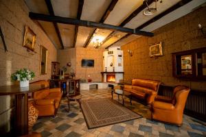 a living room with leather furniture and a fireplace at House of Dracula Hotel in Poiana Brasov